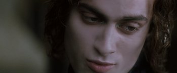 Movie still from “Queen of the Damned” (2002), directed by Michael Rymer – A person's face with a dark background; Close Up shot, High angle