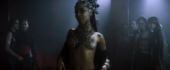 Movie still from “Queen of the Damned” (2002), directed by Michael Rymer – A woman in a body suit and a necklace; Medium shot, High angle