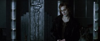 Movie still from “Queen of the Damned” (2002), directed by Michael Rymer – A man standing in front of a wall with a skeleton on it; Medium shot, Over the shoulder angle