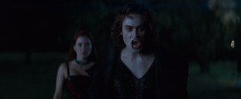 Movie still from “Queen of the Damned” (2002), directed by Michael Rymer – A woman and a man in a dark forest; Medium shot, Over the shoulder angle