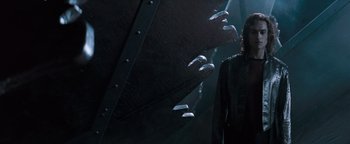 Movie still from “Queen of the Damned” (2002), directed by Michael Rymer – A man standing in front of a wall with a bunch of windows; Medium shot, Low angle