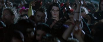 Movie still from “Queen of the Damned” (2002), directed by Michael Rymer – A man in a crowd of people wearing a black robe; Medium shot, Low angle