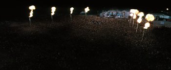 Movie still from “Queen of the Damned” (2002), directed by Michael Rymer – A crowd of people standing in front of a stage at a concert; Extreme Wide shot, High angle