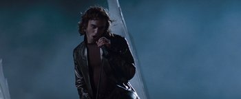 Movie still from “Queen of the Damned” (2002), directed by Michael Rymer – A man in a leather jacket is singing into a microphone; Medium shot, Low angle