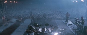 Movie still from “Queen of the Damned” (2002), directed by Michael Rymer – A crowd of people watching a band perform on a stage; Extreme Wide shot, High angle