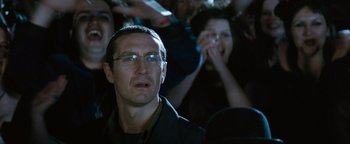 Movie still from “Queen of the Damned” (2002), directed by Michael Rymer – A man in a crowd of people watching a movie; Close Up shot, Over the shoulder angle