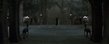 Movie still from “Queen of the Damned” (2002), directed by Michael Rymer – Two people standing in front of a stone wall; Extreme Wide shot, Low angle