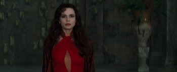 Movie still from “Queen of the Damned” (2002), directed by Michael Rymer – A woman in a red dress standing in front of a wall; Medium shot, Over the shoulder angle