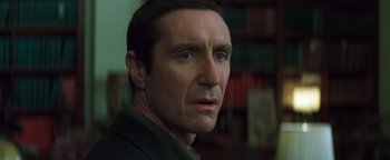 Movie still from “Queen of the Damned” (2002), directed by Michael Rymer – A man's face in front of a bookshelf; Close Up shot, Over the shoulder angle