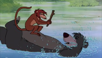 Movie still from “The Jungle Book” (1967), directed by Wolfgang Reitherman – An animated monkey riding on the back of a black bear; Medium shot, Low angle