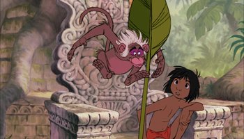 Movie still from “The Jungle Book” (1967), directed by Wolfgang Reitherman – A monkey hanging from a tree next to a boy; Wide shot, Low angle
