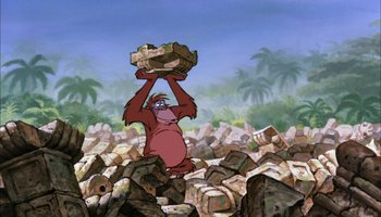 Movie still from “The Jungle Book” (1967), directed by Wolfgang Reitherman – A cartoon of a monkey holding a basket of rocks in his hands; Wide shot, Low angle