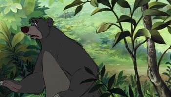 Movie still from “The Jungle Book” (1967), directed by Wolfgang Reitherman – An animated bear is sitting in the grass; Medium shot, Low angle