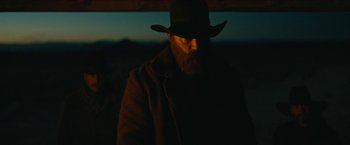 Movie still from “The Kid” (2019), directed by Vincent D'Onofrio – A man with a beard wearing a black hat; Medium shot, Low angle