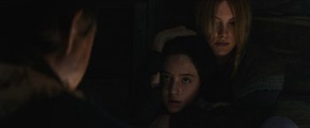 Movie still from “The Kid” (2019), directed by Vincent D'Onofrio – A girl is looking into the camera while a woman holds her hair; Close Up shot, Over the shoulder angle