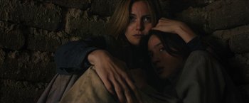 Movie still from “The Kid” (2019), directed by Vincent D'Onofrio – Two women are posing for a picture in a dark room; Close Up shot, Low angle