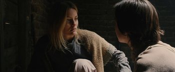 Movie still from “The Kid” (2019), directed by Vincent D'Onofrio – A woman sitting on the ground with another woman; Close Up shot, Over the shoulder angle