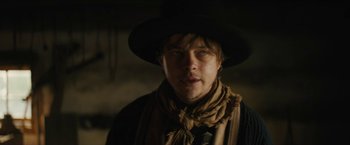 Movie still from “The Kid” (2019), directed by Vincent D'Onofrio – A man wearing a black hat and a scarf; Close Up shot, Low angle