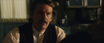 Movie still from “The Kid” (2019), directed by Vincent D'Onofrio – A person sitting in a room; Close Up shot, Over the shoulder angle