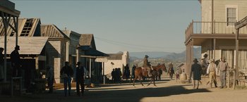 Movie still from “The Kid” (2019), directed by Vincent D'Onofrio – A man riding a horse down a street; Extreme Wide shot, Low angle