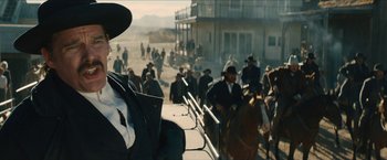 Movie still from “The Kid” (2019), directed by Vincent D'Onofrio – A group of men in hats and suits walking down a street; Medium shot, Low angle