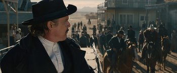 Movie still from “The Kid” (2019), directed by Vincent D'Onofrio – A man wearing a black hat and a black suit; Medium shot, Over the shoulder angle