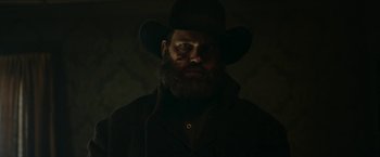 Movie still from “The Kid” (2019), directed by Vincent D'Onofrio – A man with a long beard wearing a black hat; Close Up shot, Low angle