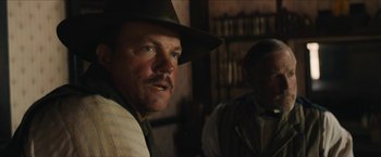 Movie still from “The Kid” (2019), directed by Vincent D'Onofrio – A man with a hat and a mustache looking into the camera; Close Up shot, Over the shoulder angle