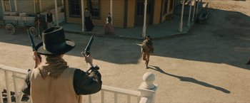 Movie still from “The Kid” (2019), directed by Vincent D'Onofrio – A man is running while holding a gun and a rifle; Wide shot, Over the shoulder angle