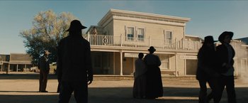 Movie still from “The Kid” (2019), directed by Vincent D'Onofrio – A group of people standing in front of a building; Extreme Wide shot, Low angle