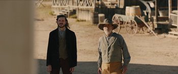 Movie still from “The Kid” (2019), directed by Vincent D'Onofrio – Two men standing next to each other on a dirt field; Wide shot, Over the shoulder angle