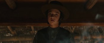Movie still from “The Kid” (2019), directed by Vincent D'Onofrio – A young man wearing a cowboy hat in the dark; Close Up shot, Low angle
