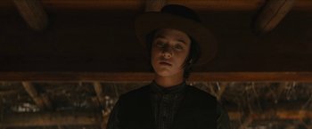 Movie still from “The Kid” (2019), directed by Vincent D'Onofrio – A young man wearing a hat and a black shirt; Close Up shot, Low angle