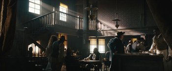 Movie still from “The Kid” (2019), directed by Vincent D'Onofrio – A group of people sitting around a table in a room; Wide shot, Low angle