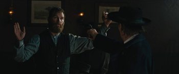 Movie still from “The Kid” (2019), directed by Vincent D'Onofrio – A man holding a gun up to another man's face; Medium shot, Over the shoulder angle