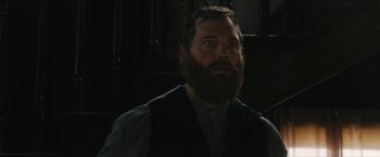 Movie still from “The Kid” (2019), directed by Vincent D'Onofrio – A man with a long beard is standing in a dark room; Close Up shot, Low angle