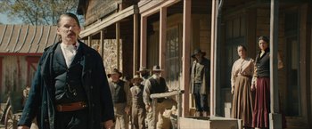 Movie still from “The Kid” (2019), directed by Vincent D'Onofrio – A group of men standing in front of a building; Medium shot, Over the shoulder angle