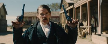 Movie still from “The Kid” (2019), directed by Vincent D'Onofrio – A man holding a gun in his right hand; Medium shot, Over the shoulder angle