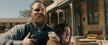 Movie still from “The Kid” (2019), directed by Vincent D'Onofrio – A man and a woman holding a gun and knife; Medium shot, Low angle