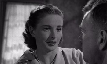 Movie still from “The Killing” (1956), directed by Stanley Kubrick – An old photo of a woman talking to a man; Close Up shot, Over the shoulder angle