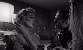 Movie still from “The Killing” (1956), directed by Stanley Kubrick – A man and a woman sitting in front of each other in a room; Close Up shot, Low angle