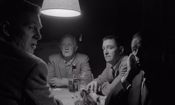 Movie still from “The Killing” (1956), directed by Stanley Kubrick – A black and white photo of people sitting at a table; Medium shot, Low angle