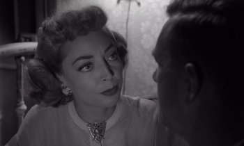 Movie still from “The Killing” (1956), directed by Stanley Kubrick – An old photo of a man and a woman; Close Up shot, Over the shoulder angle