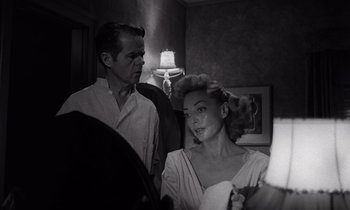 Movie still from “The Killing” (1956), directed by Stanley Kubrick – A man and a woman are getting ready to go out; Medium shot, Low angle