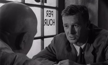 Movie still from “The Killing” (1956), directed by Stanley Kubrick – A black and white photo of a man talking to another man; Close Up shot, Over the shoulder angle