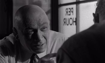 Movie still from “The Killing” (1956), directed by Stanley Kubrick – An older bald man wearing a white shirt and a tie; Close Up shot, Over the shoulder angle