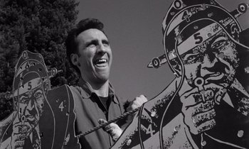 Movie still from “The Killing” (1956), directed by Stanley Kubrick – A black and white photo of a man laughing; Medium shot, Low angle