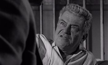 Movie still from “The Killing” (1956), directed by Stanley Kubrick – An older man is looking at the camera; Close Up shot, Low angle