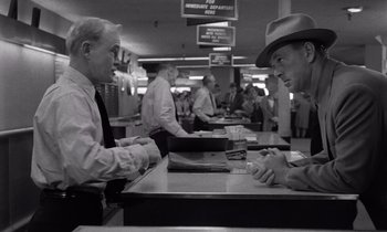 Movie still from “The Killing” (1956), directed by Stanley Kubrick – Two men are sitting at a counter in a restaurant; Medium shot, Low angle