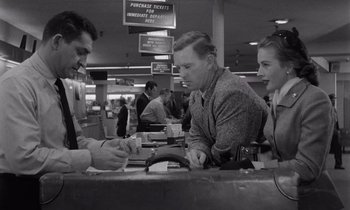 Movie still from “The Killing” (1956), directed by Stanley Kubrick – A group of people sitting at a counter; Medium shot, Low angle